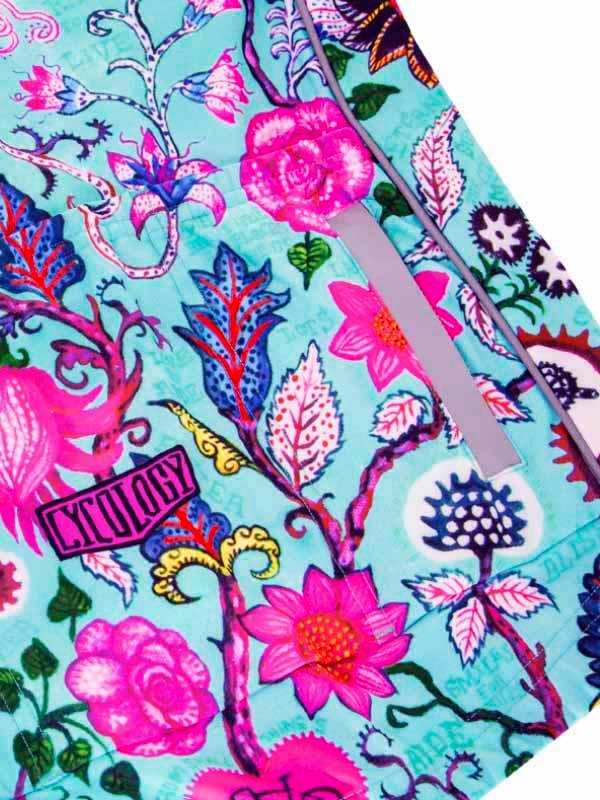 Vibrant floral cycling jersey with pink roses, blue leaves, and 'CYCOLOGY' logo on teal fabric