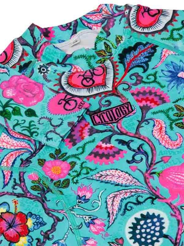 Vibrant floral cycling jersey with pink roses, teal background, and bike-themed graphics for women's bike wear
