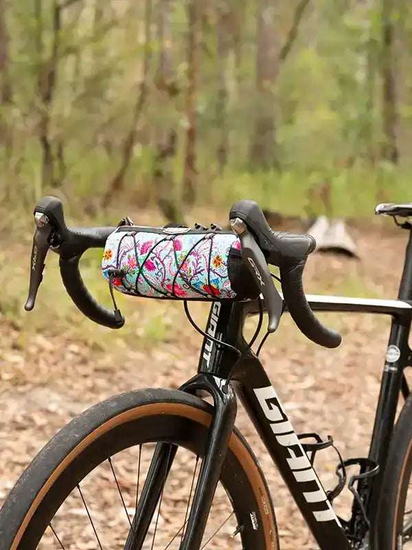 Floral patterned bike handlebar bag on road bicycle in forest setting