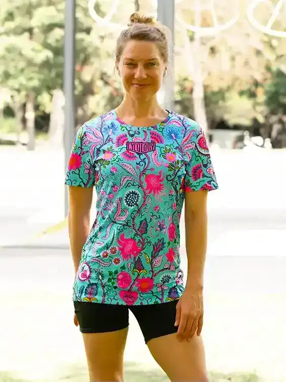 Woman wearing vibrant floral cycling jersey and black shorts, ideal for active rides and outdoor fitness.