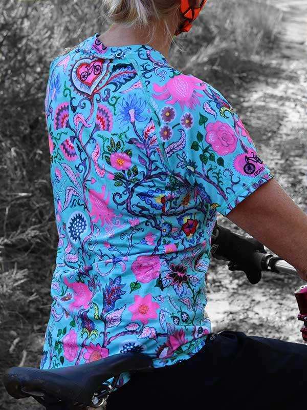 Woman cycling in vibrant floral print jersey, colorful bike apparel for outdoor rides