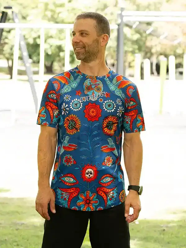 Man wearing vibrant floral and skull print cycling jersey, ideal for men's cycling apparel