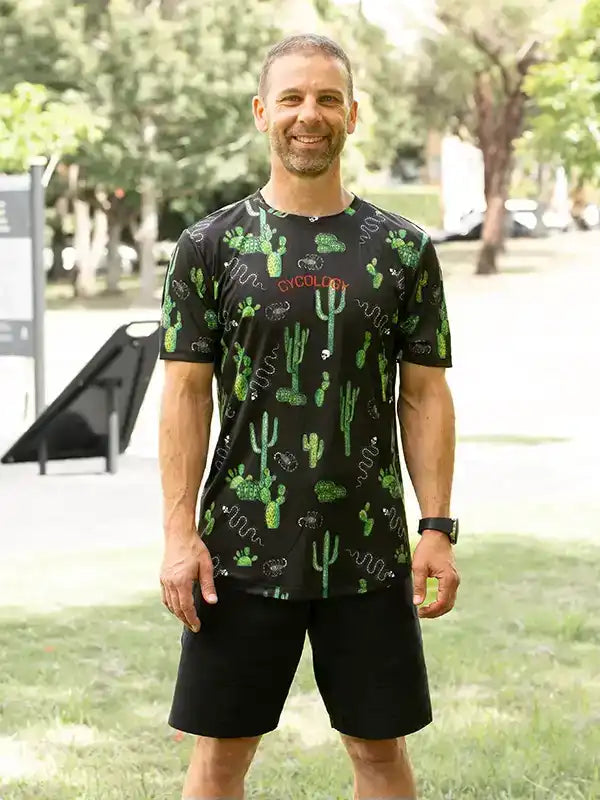 Men's cycling jersey with cactus print, black shorts, outdoor park setting