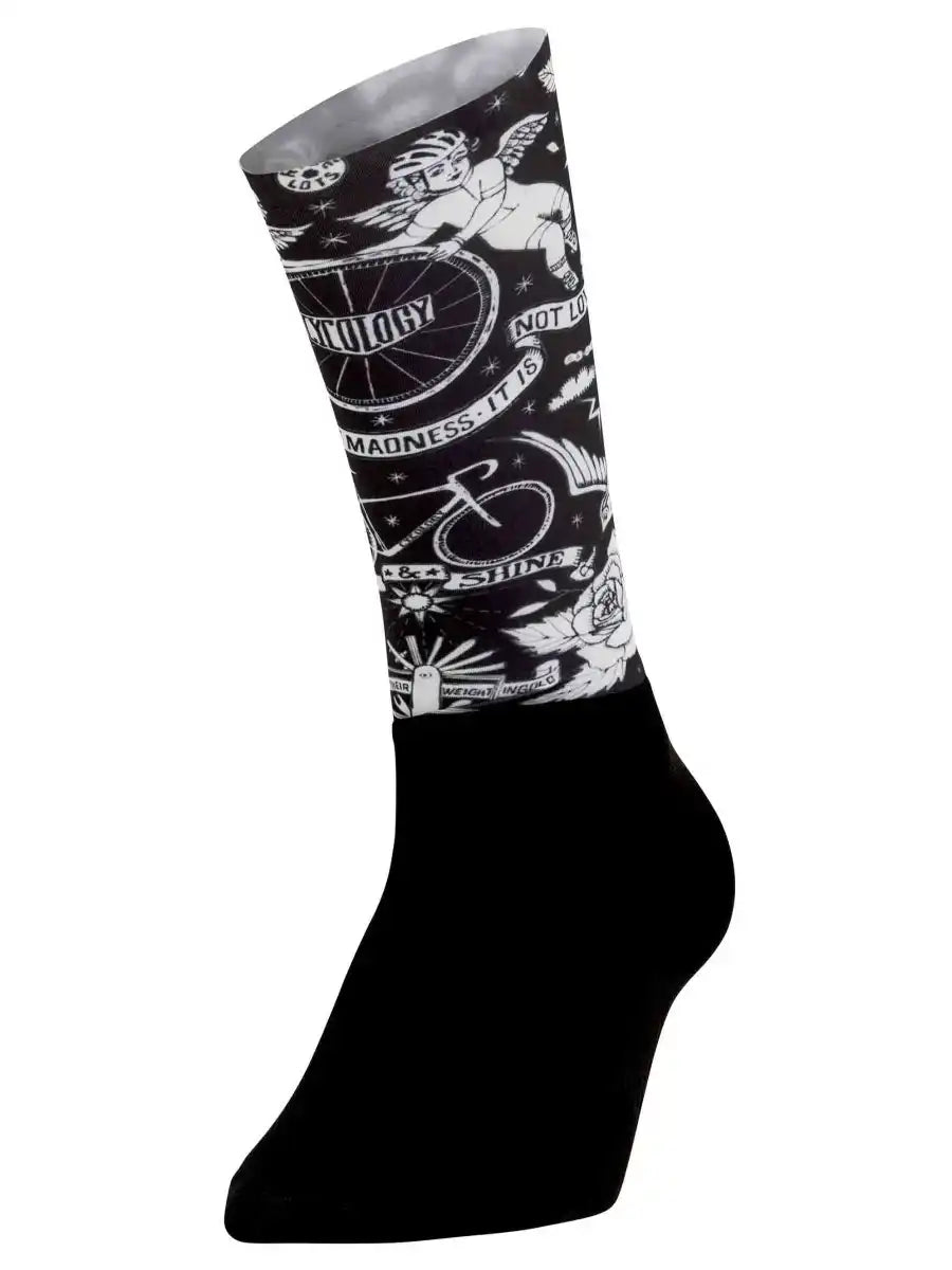 Black cycling sock with white tattoo-style graphics including cherub, bike wheel, and 'Madness It Is' text