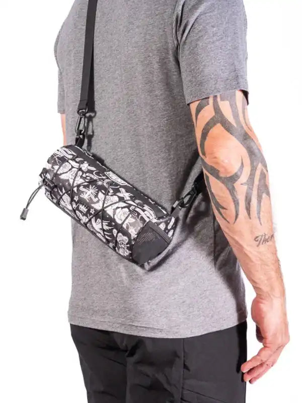 Black and white patterned cycling waist bag worn by man with tattooed arm