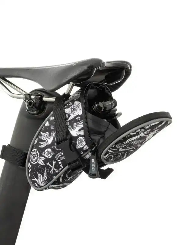 Black and white floral patterned cycling saddle bag with tools, attached to bike seat