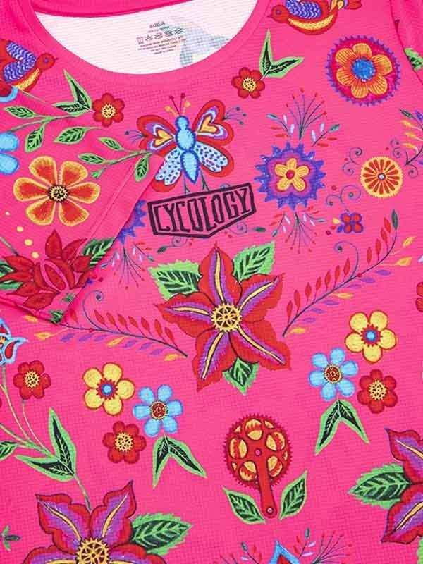 Vibrant pink cycling jersey with floral and butterfly print, featuring bold colors and artistic design for women's cycling wear.